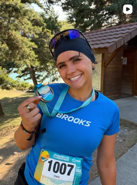 Clara Pichon portant son dossard et montrant sa médaille à l’issue du trail.
