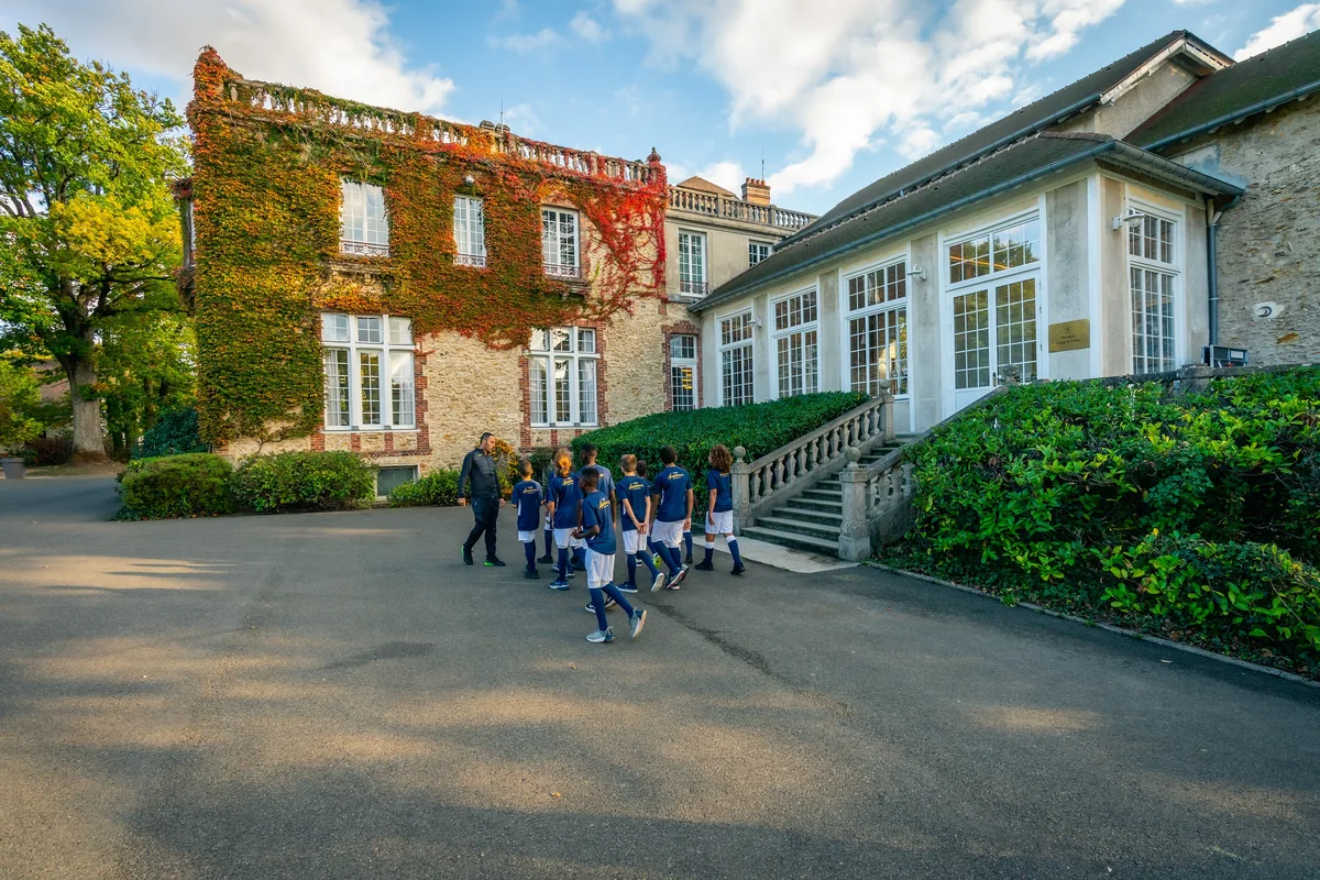 Joueuses de l’Équipe de France féminine devant un bâtiment et ses jardins.