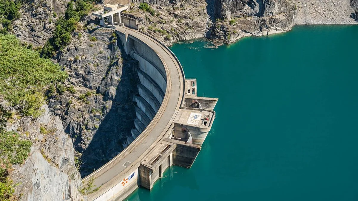 Vue aérienne d’un barrage hydroélectrique et du lac, contexte de la campagne de prévention.